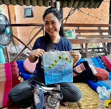 A human rights activists shows her painting to promote women's participation in peacebuilding.