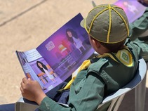 A Libyan Scout reads the USAID enviornmental education book "Lubaba and the Magical Garbage" in Kabaw