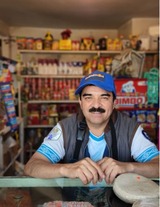 A Propaga client stands at his storefront in Mexico City, showing off his fully-stocked shelves.