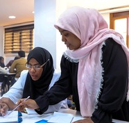 Rabia Al-Mabrouk works with another participant on a business development plan.