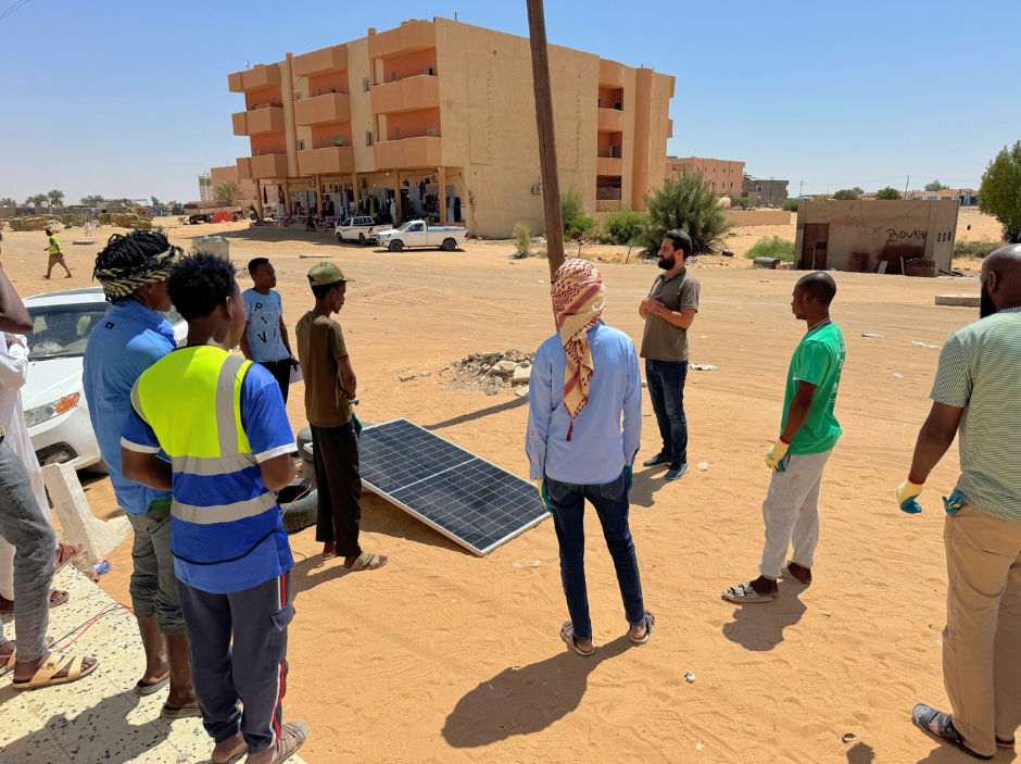 Al-Enara Al-Badeela employees install solar panels at a blood bank.