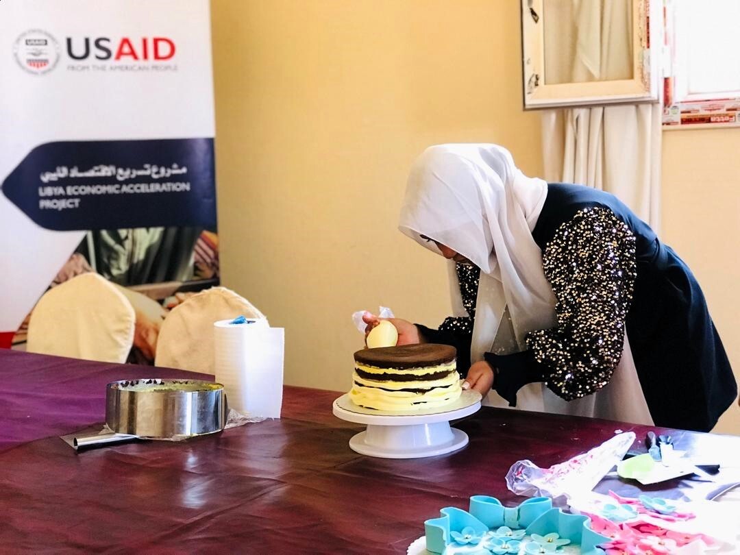 Participant practices cake decorating skills during the twenty day hospitality training. 