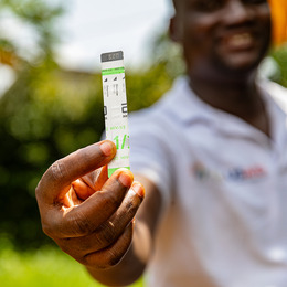 A man's hand holding an HIV testing strip.