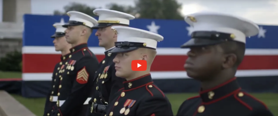 Video thumbnail for America250's PSA video. Still image of 5 Marines looking straight ahead. 
