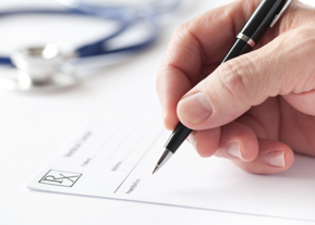 Hand and pen writing on prescription pad 
