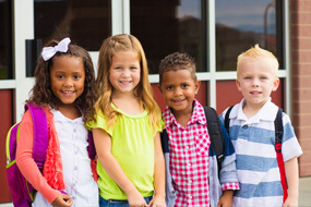 Children standing outside of a building