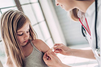 health care professional applying band aid to child
