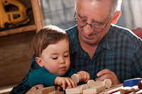 boy and grandfather holding wooden toy