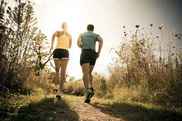 a woman and a man running on a trail 