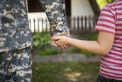 Military Service Member Holding Child's Hand