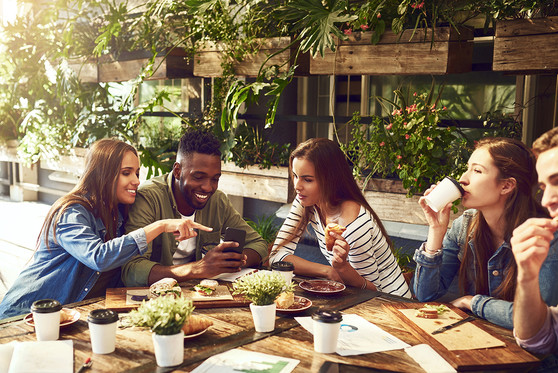 Young adults hanging out and eating a meal together at a restaurant