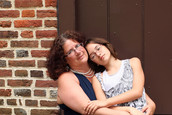 A mother hugs her concerned daughter.