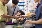 A family uses a SNAP electronic benefits transfer card to purchase food at a grocery store.