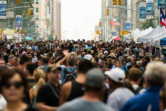 People crowd a street in New York City.