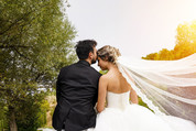 Groom kisses bride on forehead. Posterior view. 