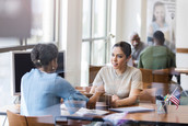 Two women sitting across from each other at a table