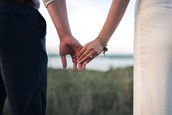 A man and his wife hold hands while catching a scenic view.