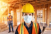 Construction workers survey a structure.