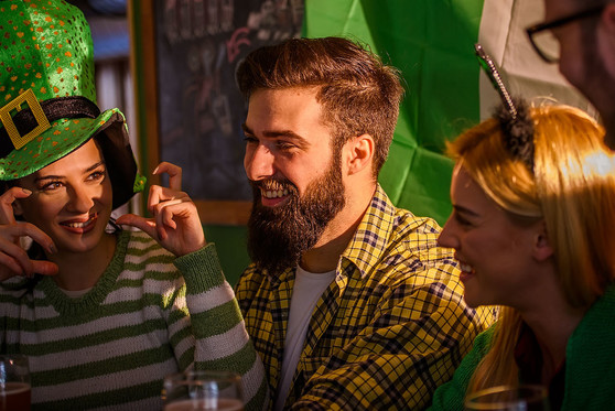 Three friends celebrate St. Patrick's Day together at a restaurant.