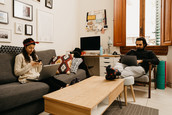 A man and woman who share a living space work from home in a common area of their dwelling.