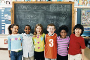 Students pose in front of a blackboard during their math class.