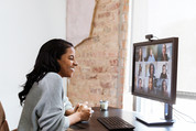 A woman talks with her colleagues via video conference.