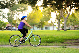 A woman wears a face mask while riding a bicycle.