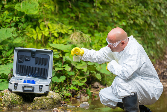 A scientist examines toxic water.