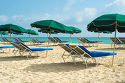 Umbrellas and beach chairs set up at a beach without people