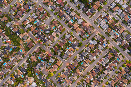 An aerial view of several city blocks of houses.
