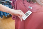 A customer looks at a t-shirt in a retail store.