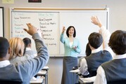 A teacher lectures to her class and calls on a student to answer a question.