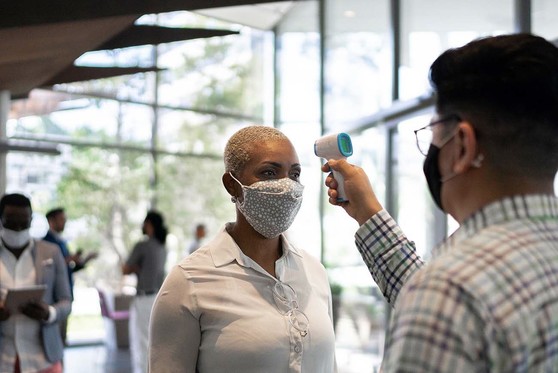 A woman has her body temperature checked.