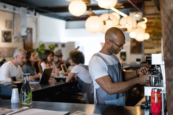 A barista makes coffee at a cafe.