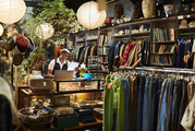 An employee stands behind a counter in a retail store.