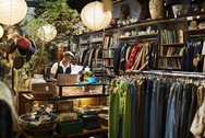 An employee stands behind a counter in a retail store.