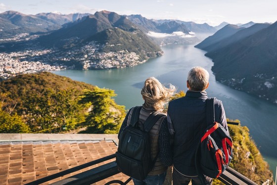 An older couple at a scenic viewpoint by a lake