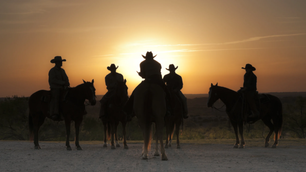 Cowboys and a cowgirl at sunrise in Texas