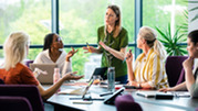 Women discuss ideas and business opportunities in a board room.