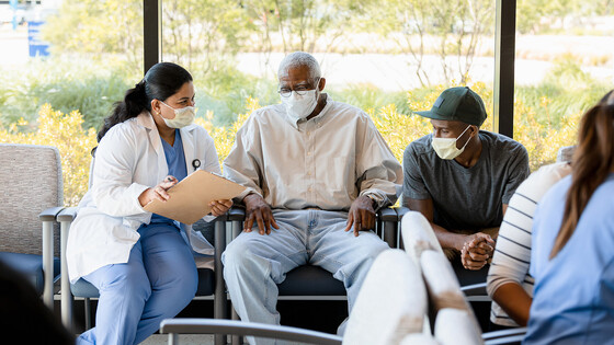 Men consult with a doctor at a medical facility.