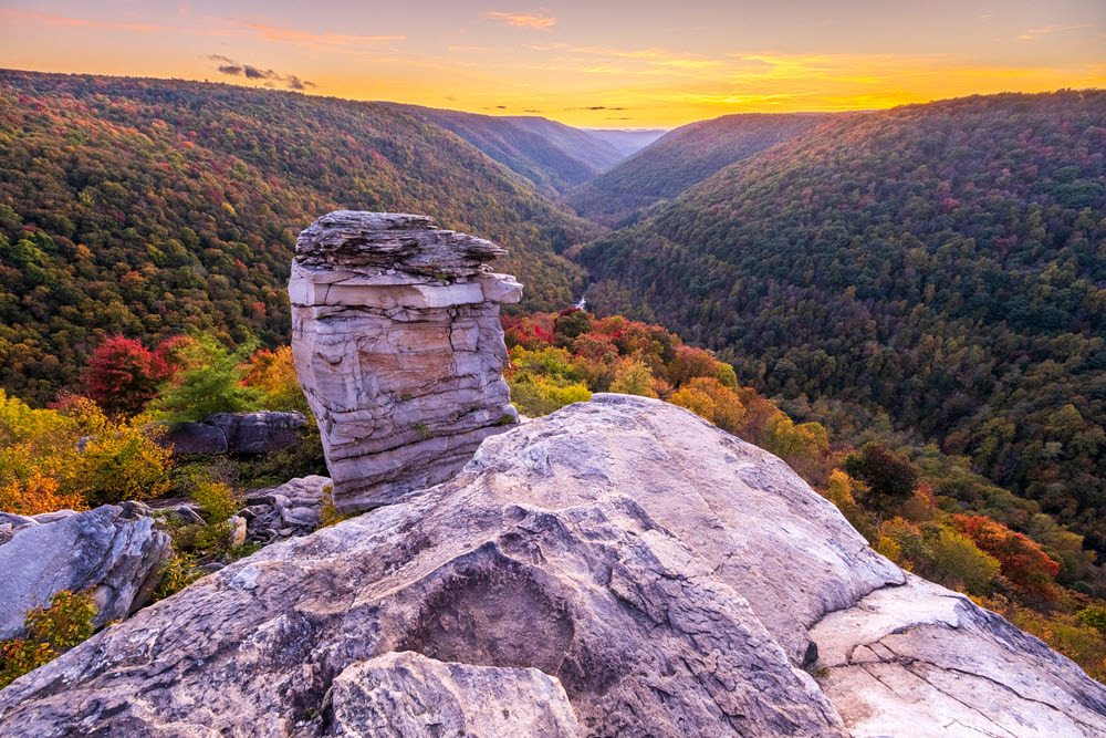 An autumn sunset at Lindy Point in West Virginia, featuring fall foliage in Blackwater Canyon and the Blackwater River