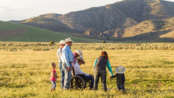 A family of farmers looks over their rural landscape.