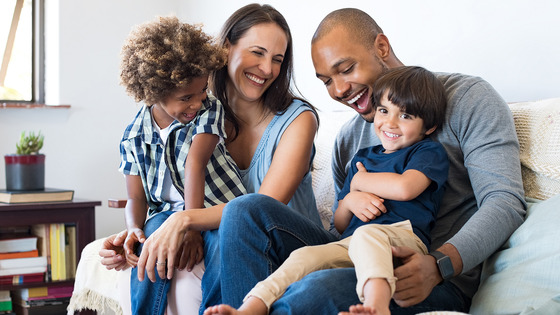 Interracial couple sit with their children