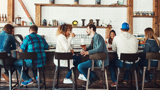 Man and woman talk at bar 