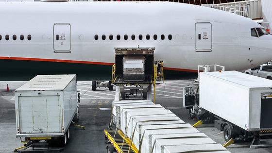 Trucks carrying freight to be loaded on to an airplane.