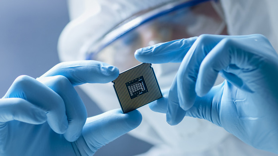 Lab worker looks at computer microchip