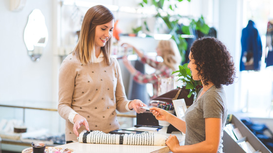 A woman purchases an item at a retail store.