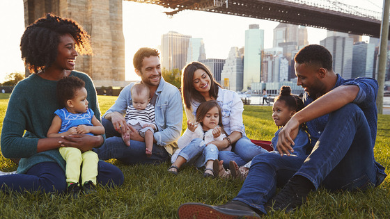 Group of parents sit outside with their children