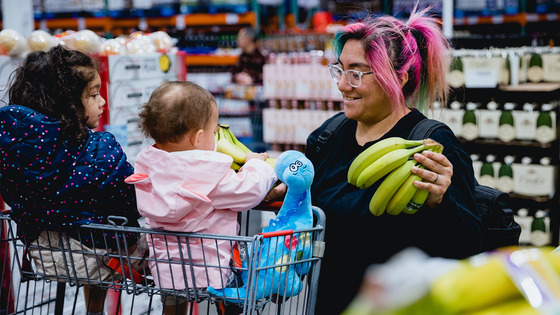 Mother and her children shop in supermarket.