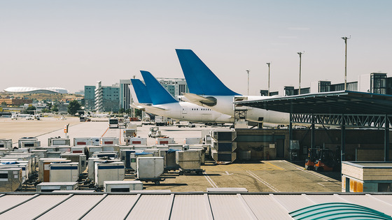  Airplanes and cargo on an airport tarmac. 